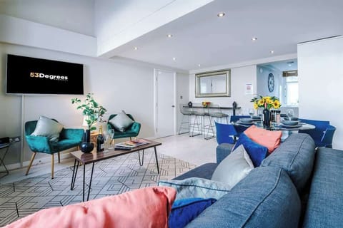 The open-plan living room and dining area benefit from a 50-inch Smart TV, a 4-seater dining table,  a 3-seater breakfast bar, plenty of space to sit down in the evenings and a double sofa bed.
