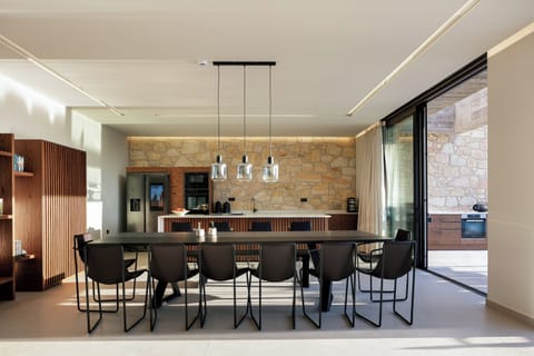 Adjacent to the kitchen, a grand dining table takes center stage, comfortably seating up to 15 guests.