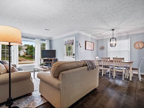 Natural light floods the living room, creating a warm and welcoming atmosphere.