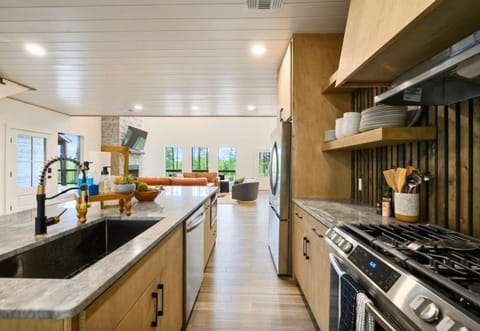 This sleek kitchen offers a gas stove, ample counter space, and a walk-in pantry for all your culinary needs.