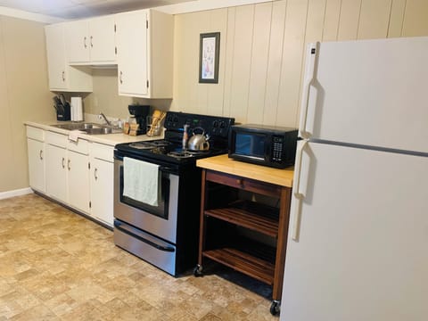 Full kitchen with essential utensils and cookware.
