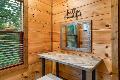Cozy cabin vanity nook with chevron desk and mirror for a relaxing retreat.