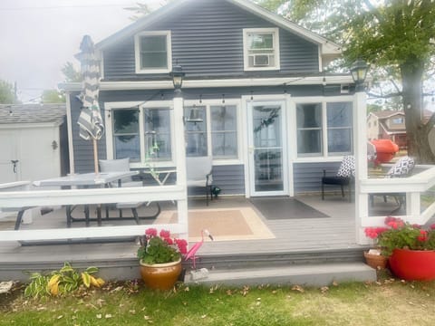 To the left of the deck is a concrete patio with a gas grill.