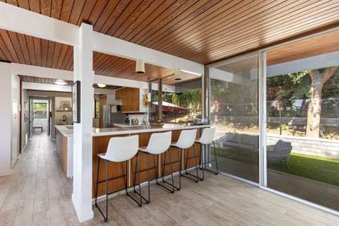 The bar area leads out to the patio, where ample seating for ten awaits, perfect for enjoying outdoor gatherings and the pleasant ambiance