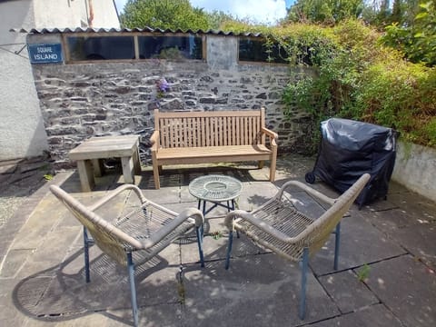 Bench and chair seating on patio in courtyard.