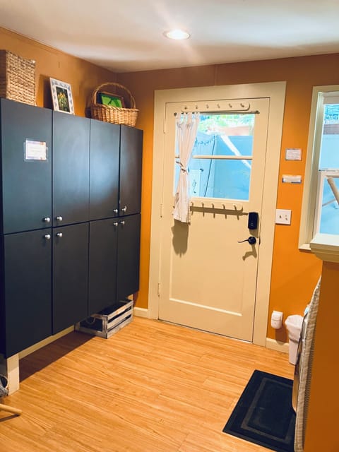 sun-filled entry with cabinets containing toys, books and laundry supplies
