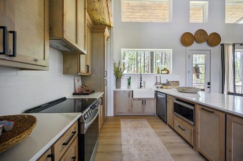 Bright kitchen with natural light, custom wood cabinetry, and stainless steel appliances for a luxury cabin feel.