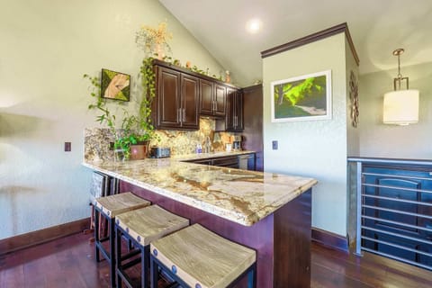 Casual dining at its best with bar seating, set against a backdrop of richly detailed countertops and vibrant plant life.