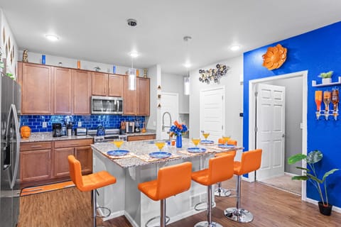 This stylish kitchen combines rich wood tones with vibrant blue tiles, offering a cozy yet contemporary dining space