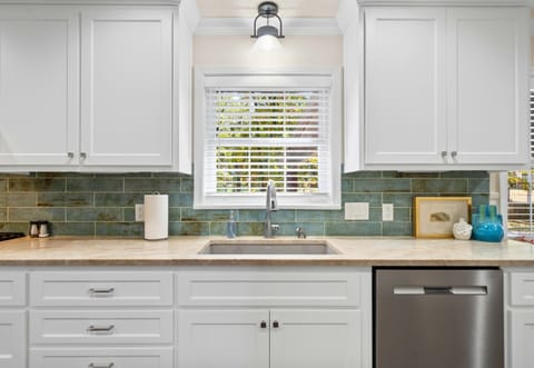 A closer look at the stylish and functional kitchen sink, with a gorgeous tile backsplash adding a modern touch.