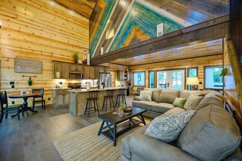 Step into a warm and inviting open-concept space with vaulted ceilings and cozy wood accents. Relax on the comfy sectional, or gather around the kitchen island to enjoy the modern touches and rustic charm of this beautiful cabin.