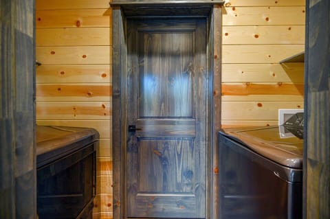 Laundry area with modern appliances, framed by natural wood walls, providing a simple and functional space.