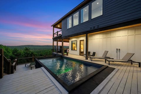 Scenic luxury cabin with illuminated private pool and sunset views—relax in comfort and style.