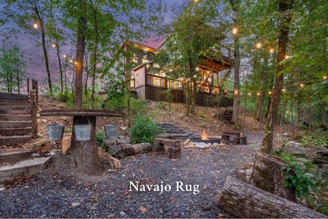 Cozy cabin retreat with firepit, string lights, and forest views