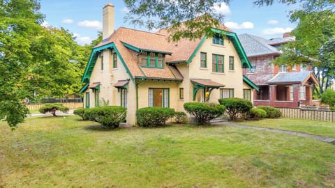 Inviting two-story yellow brick home with green trim
