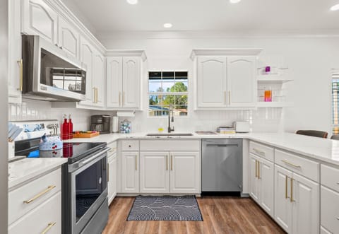This bright kitchen features modern appliances and a large island, making it the perfect space for preparing meals and enjoying casual breakfasts with friends and family.