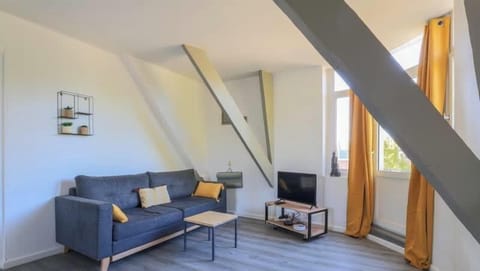 Salon avec canapé convertible, télévision, accès au balcon.
Le salon est semi ouvert sur la cuisine.