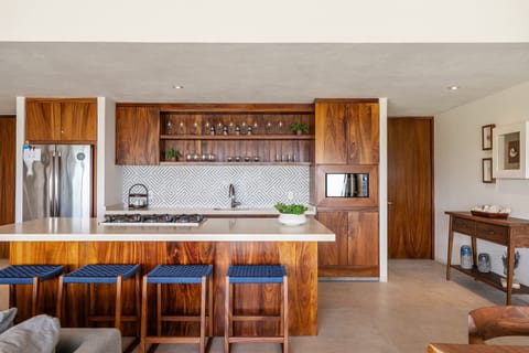 A fully equipped gourmet kitchen with high-end appliances, sleek wood cabinetry, and a spacious island—perfect for cooking and entertaining.