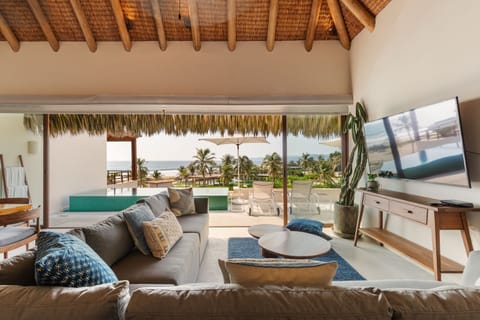 Enjoy stunning ocean views from this beautifully designed living room, featuring open-concept seating, natural light, and direct access to the terrace.
