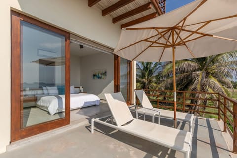 Relax on this private balcony with sun loungers, fresh ocean breezes, and breathtaking palm-lined views.