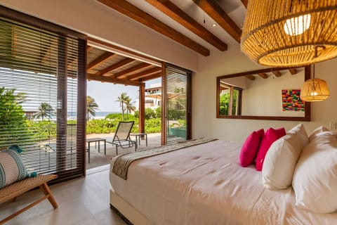 Wake up to breathtaking ocean views in this elegant bedroom, featuring warm natural tones and seamless indoor-outdoor flow.