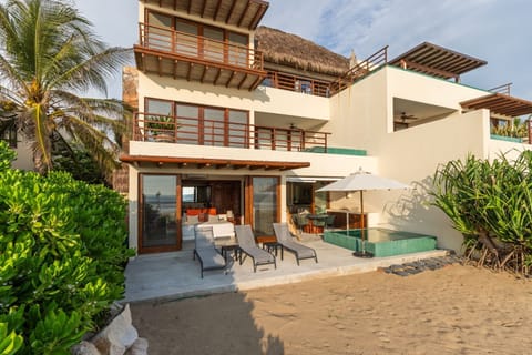 Step directly onto the beach from this stunning villa, featuring multiple terraces, ocean views, and a private plunge pool.
