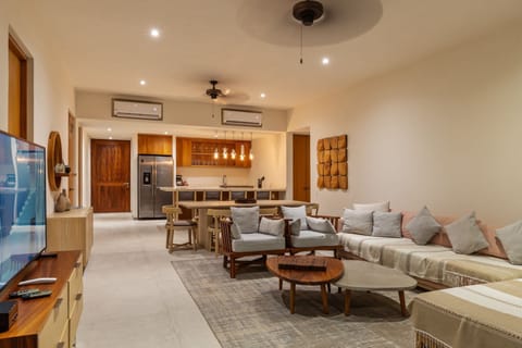 Relax in this beautifully designed living space, featuring modern lighting, custom woodwork, and a seamless transition to the fully equipped kitchen.