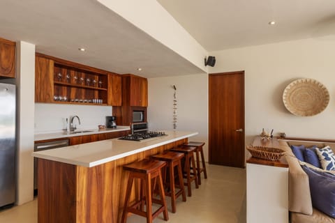 A well-appointed kitchen with sleek finishes, a spacious breakfast bar, and handcrafted wooden details.
