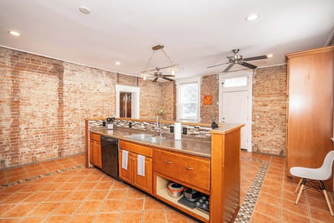The kitchen showcases exposed brick, ample space, & numerous amenities