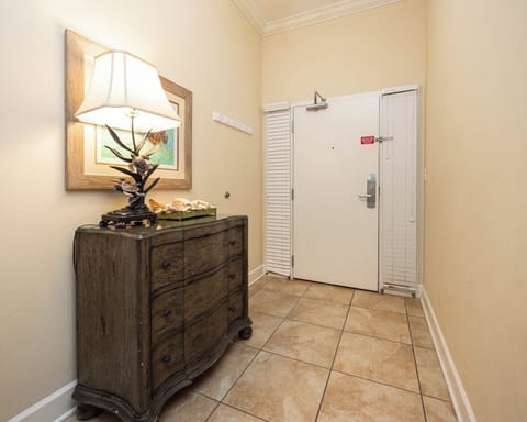 Welcoming entryway featuring a stylish chest, seashell decor, and warm lighting for a cozy atmosphere