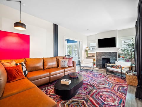 A vibrant living room, bursting with personality!  🧡  The pops of color and comfy seating make this space feel inviting. #CozyVibes