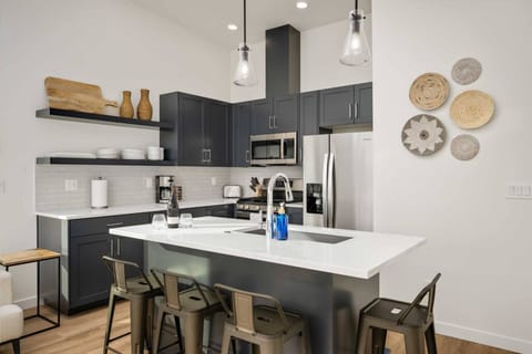 The kitchen is a hub of culinary activity, adorned with sleek countertops, stainless steel appliances, and an array of neatly organized utensils.