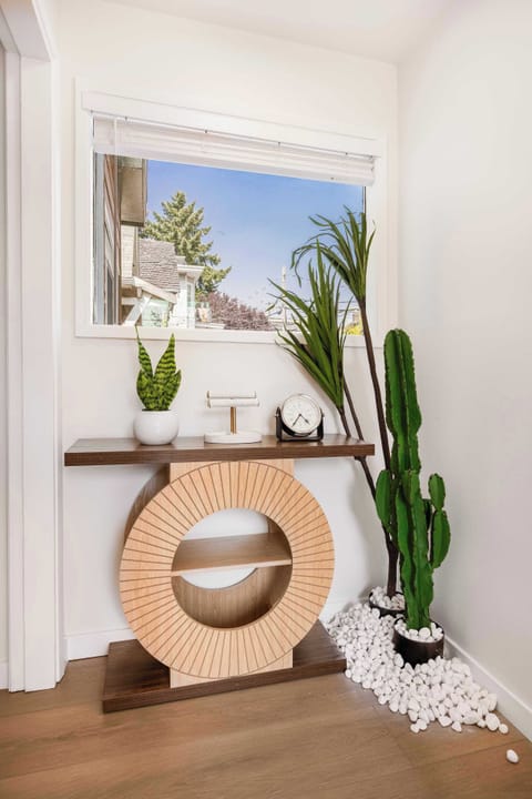 A stylish hallway nook featuring modern geometric decor and vibrant plants, creating a warm and inviting entrance.