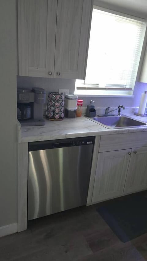 Coffee station with coffee and a new stainless steel dishwasher