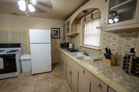 Fully stocked kitchen with original 1950s cabinets and aesthetics
