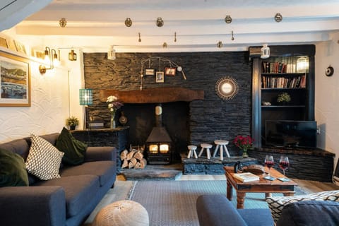 Lounge with sofas, coffee table, tv, fireplace with woodburner