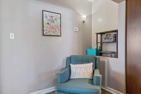 Cozy seating area for one near the kitchen and bedrooms, perfect for reading a book.