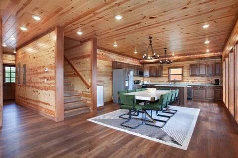 Spacious kitchen with island seating, stainless steel appliances, and cabin elegance.