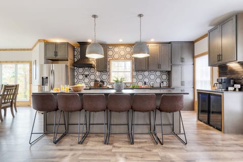 Kitchen features an island with barstool seating and stainless steel appliances.