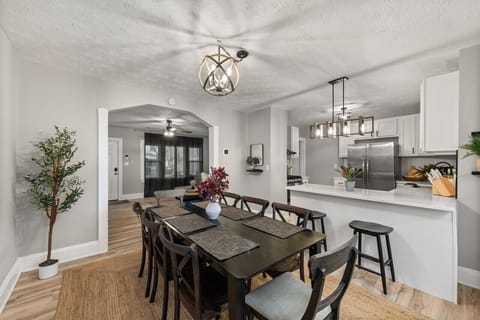 `Enjoy meals and conversations at this spacious 8-person dining table, overlooking a gourmet kitchen and sleek bar counter.