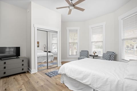 Primary Bedroom: Bright and airy retreat with modern decor and accent chairs perfect for relaxation after city adventures!