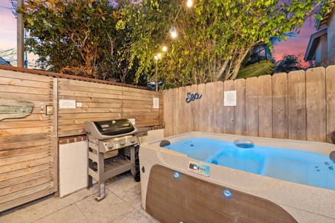 Unwind in the hot tub after a delicious meal from the barbecue grill in this private and lush backyard retreat.