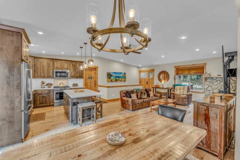 Main living space: Open layout, 3-cushion couch, 1 recliner, 65” Smart TV w/DVD player, wood-burning fireplace, 6-person dining table, well-equipped kitchen