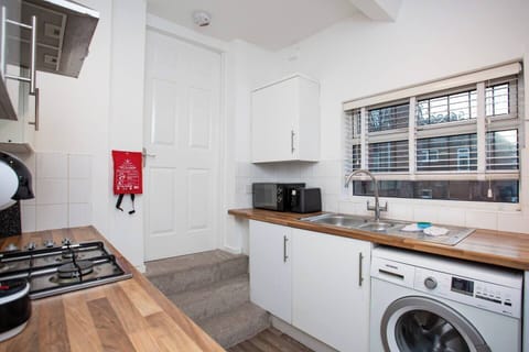 Modern, fully equipped kitchen with sleek cabinets and essential appliances. Compact and functional.