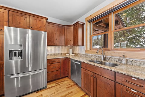 Full kitchen with stainless steel appliances, and breakfast bar seating 3.