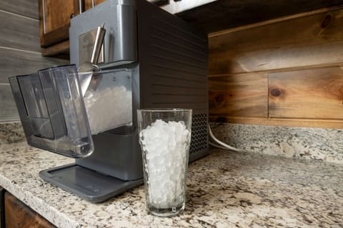 Sleek ice maker on granite countertop for chilled drinks during your vacation.