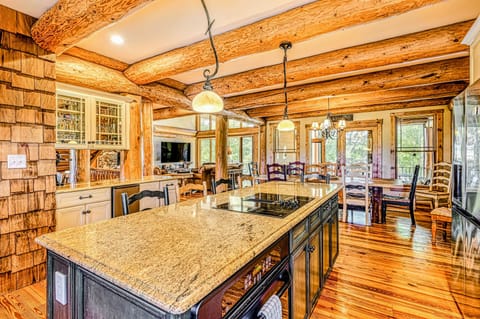 Cook and gather in this spacious gourmet kitchen featuring granite countertops, rustic wood beams, and an open layout leading to a cozy dining area.