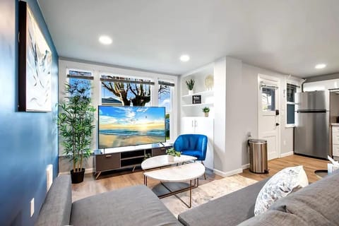 A stylish space to unwind, complete with a vibrant blue chair, sleek furniture, and a breathtaking view from the large windows.