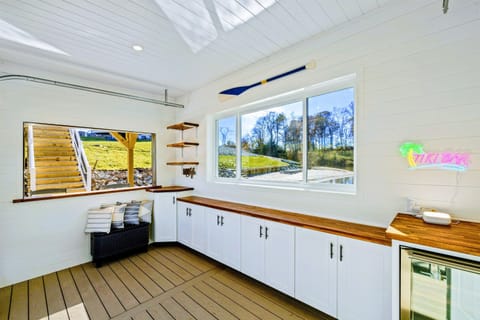 Bright and stylish lake-themed interior with ample counter space, nautical decor, and large windows for a perfect indoor-outdoor vibe