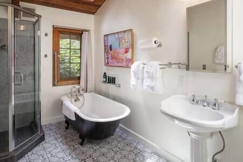 Cute bathroom with nice tile, powerful double head shower, and a large clawfoot tub for soaking in!